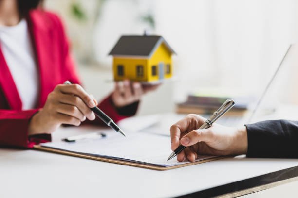Businesswoman discusses with real estate agent, negotiates and signs contract for purchase of house and land. Wills and inheritance.