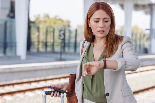 Worried businesswoman checking the time on her wristwatch at the train station.