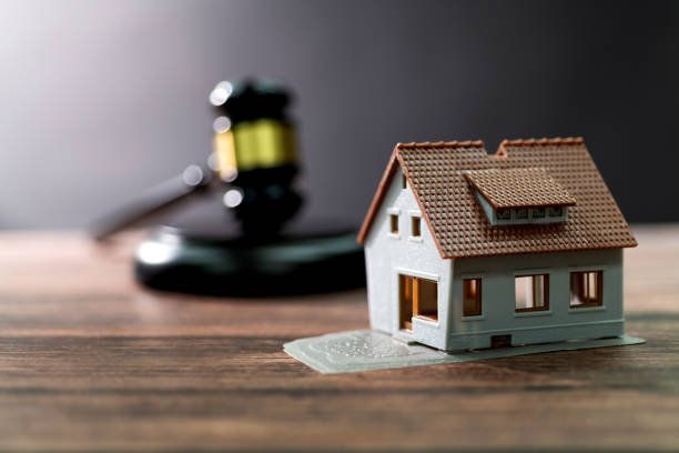 Gavel and model house on the table.