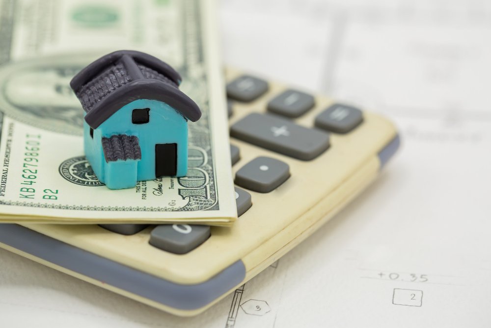 House on the calculator with dollar bills 