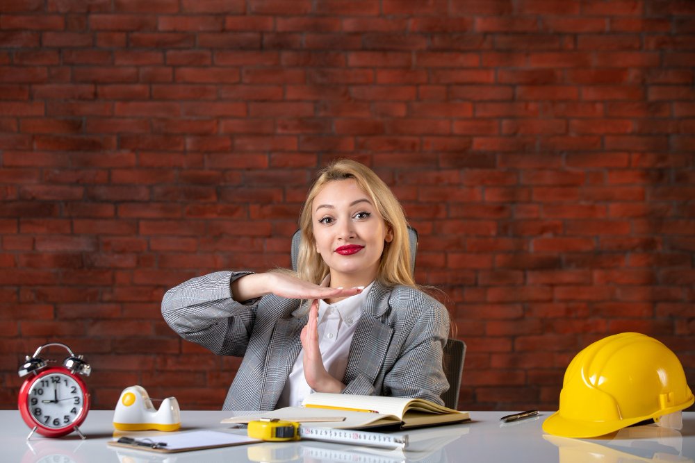 Front view female engineer sitting behind her working place 