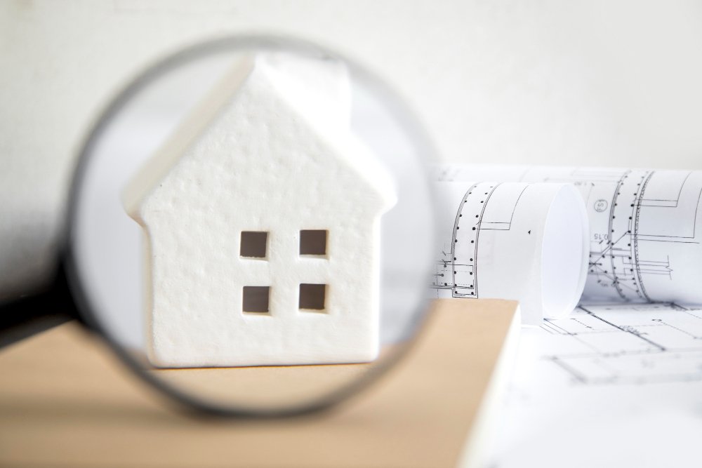 Toy house behind magnifying glass 