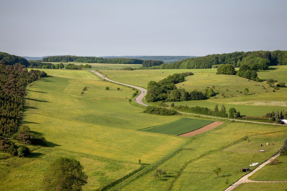 Aerial shot of farmland under the clear sky in the eifel region, germany 
