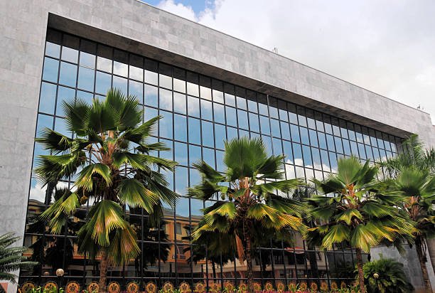 Victoria, Mahé Island, Seychelles: headquarters of the Central Bank of Seychelles (CBS) - established on December 1, 1982, as the successor to the Seychelles Monetary Authority, the institution serves as the principal monetary and regulatory body of the Republic of Seychelles. Its primary objectives include the maintenance of domestic price stability and the promotion of a sound financial system. The bank is responsible for the formulation of monetary policy, the management of foreign reserves, and the issuance of the national currency, the Seychelles Rupee (SCR). The architectural design features a prominent glass curtain wall and stone framing, reflecting the modernization of the country's financial infrastructure. Seychelles is widely recognized as a popular offshore financial center and has traditionally been considered a tax haven due to its favorable tax policies for international businesses.